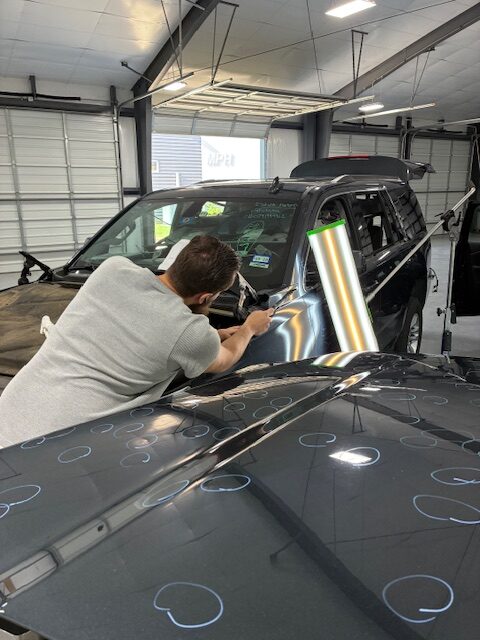 IMG_0089 A man working on the hood of a car.